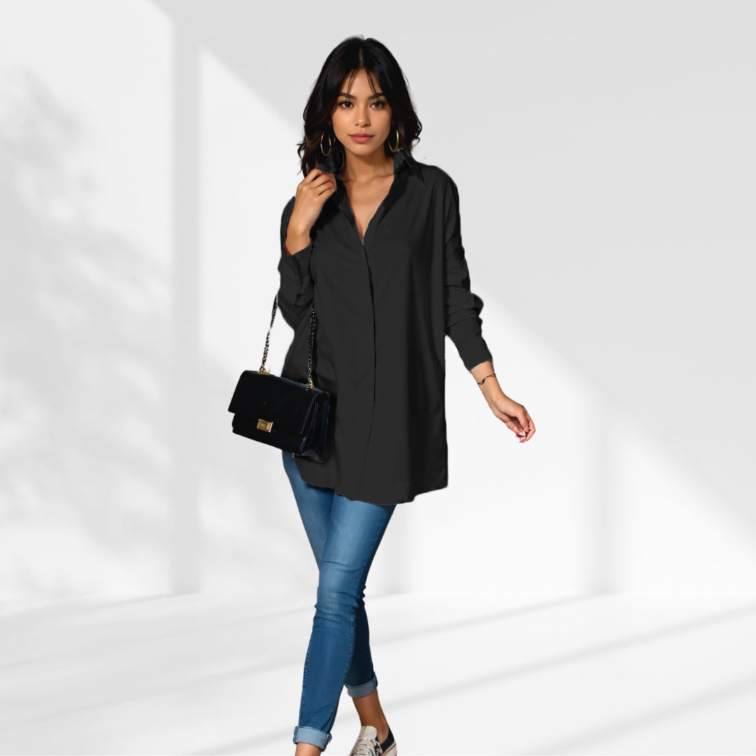 woman wearing a black oversized shirt dress facing forward showcasing the fit and style.