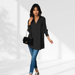 woman wearing a black oversized shirt dress facing forward showcasing the fit and style.