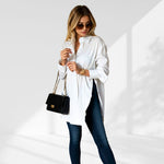 woman wearing a white oversized shirt dress facing forward showcasing the fit and style.