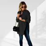woman wearing a black oversized shirt dress facing forward showcasing the fit and style.
