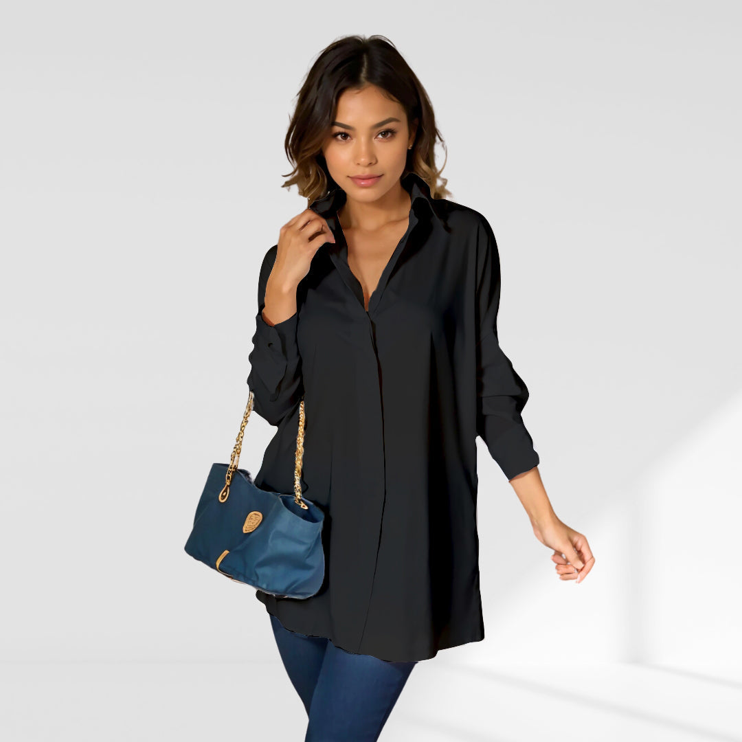 woman wearing a black 
oversized shirt dress facing forward showcasing the fit and style.