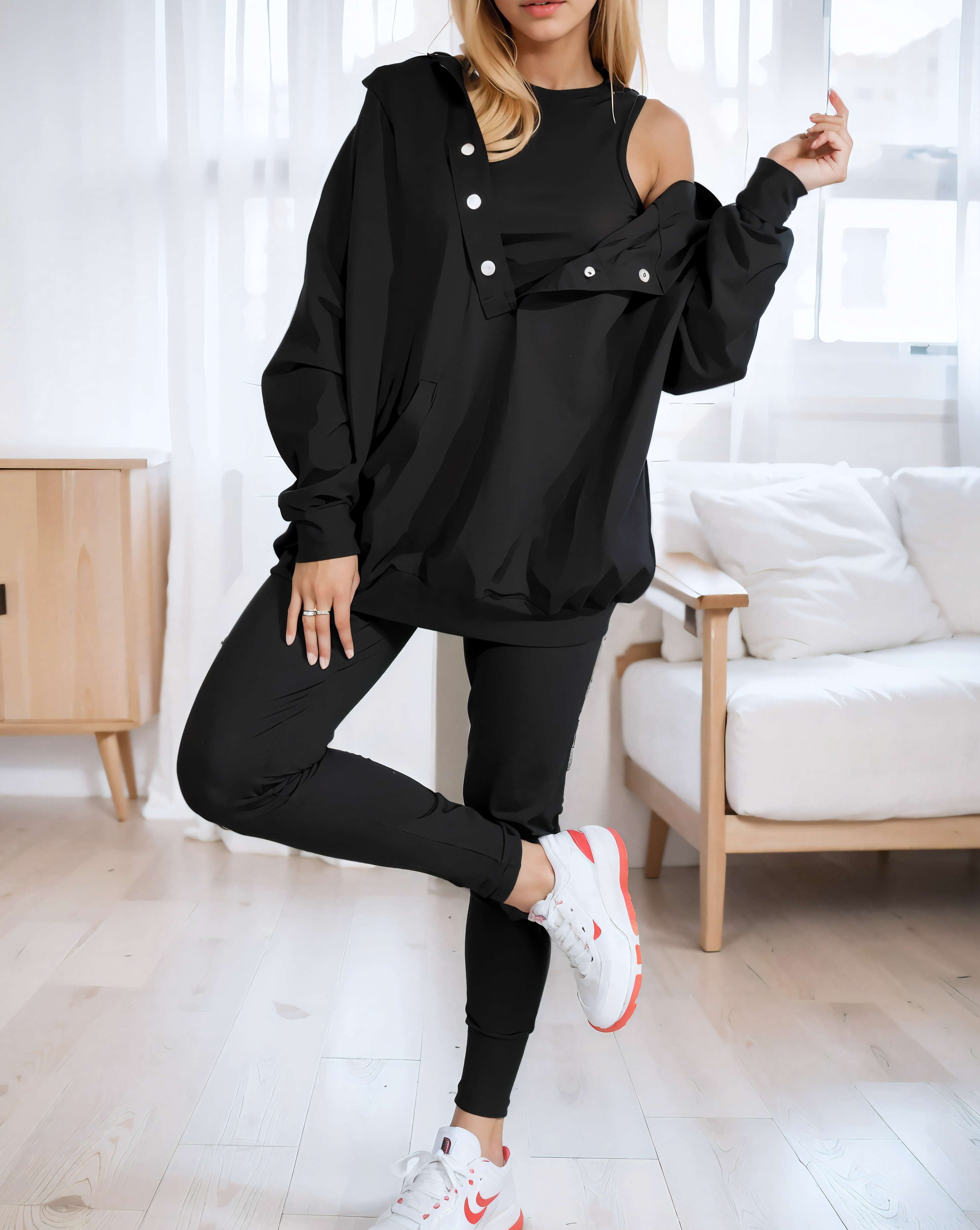 woman wearing a oversized snap fit black hoodie facing forward showcasing the fit and style.