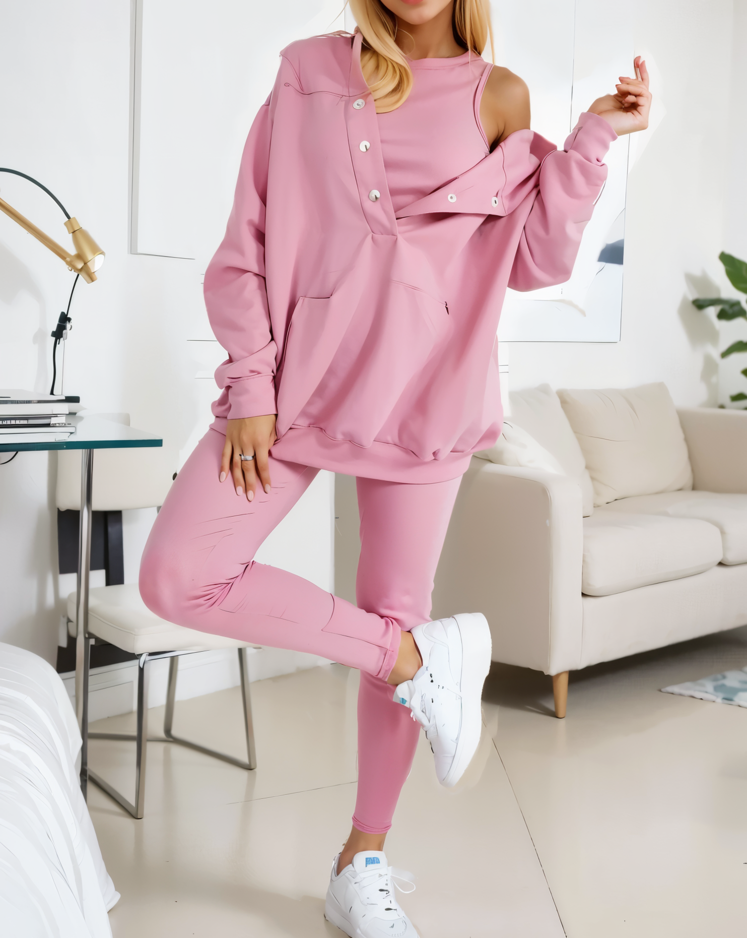 woman wearing a oversized snap fit pink hoodie facing forward showcasing the fit and style.