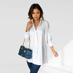 woman wearing a white oversized shirt dress facing forward showcasing the fit and style.