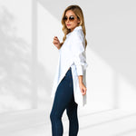woman wearing a white oversized shirt dress facing forward showcasing the fit and style.