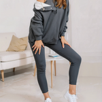 woman wearing a oversized snap fit gray hoodie facing forward showcasing the fit and style.