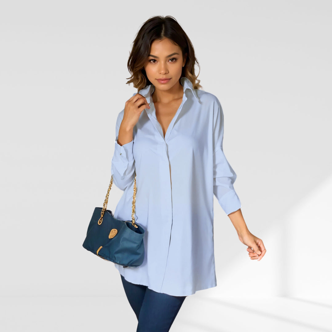 woman wearing a blue oversized shirt dress facing forward showcasing the fit and style.