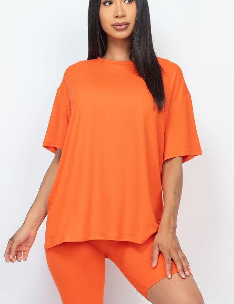Women wearing orange 2pc set facing forward